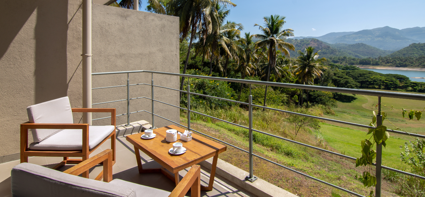 Sunrise Ridge Villa Exterior Balcony with sitting chairs and view of the reservoir, mountains and practice range